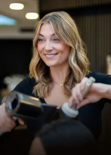 Ariane, Premium Master Stylistin bei Haarem Erding, beim Styling und Finish einer Balayage-Färbung.