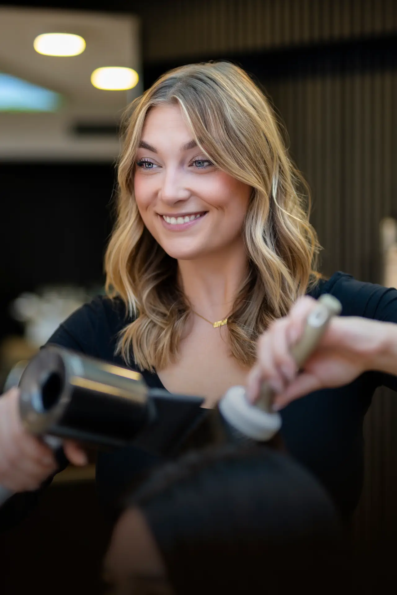 Ariane, Premium Master Stylistin bei Haarem Erding, beim Styling und Finish einer Balayage-Färbung.