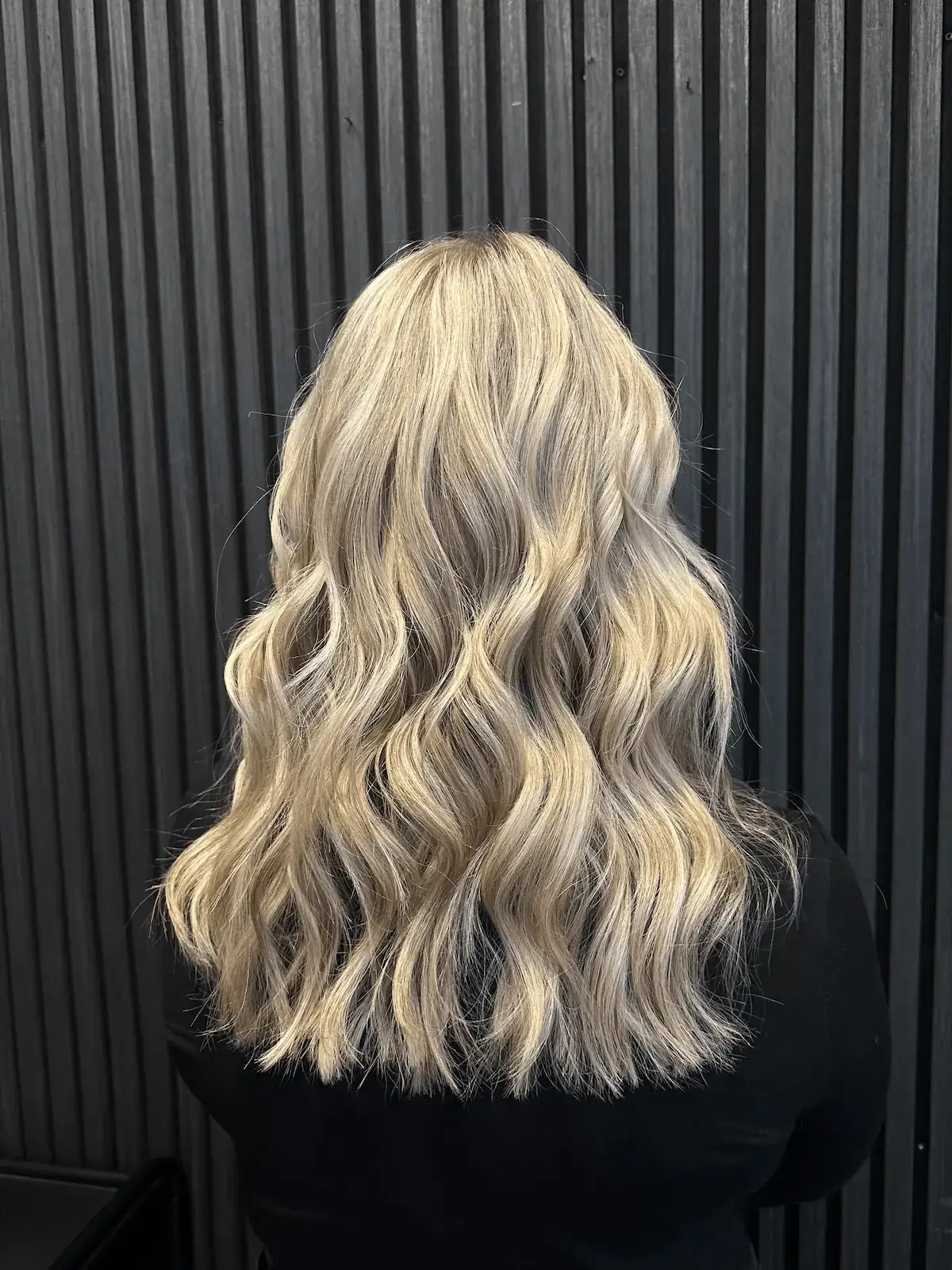 Nachher-Ergebnis einer fließenden, hellblonden Balayage mit sanften Wellen (Waves) bei Haarem Erding.